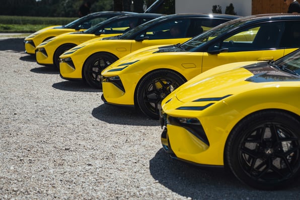 A line up of yellow Lotus cars, with just the bonnets visible