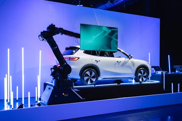 The Geely EX5 with a robot screen in front of it showing the technology of the car