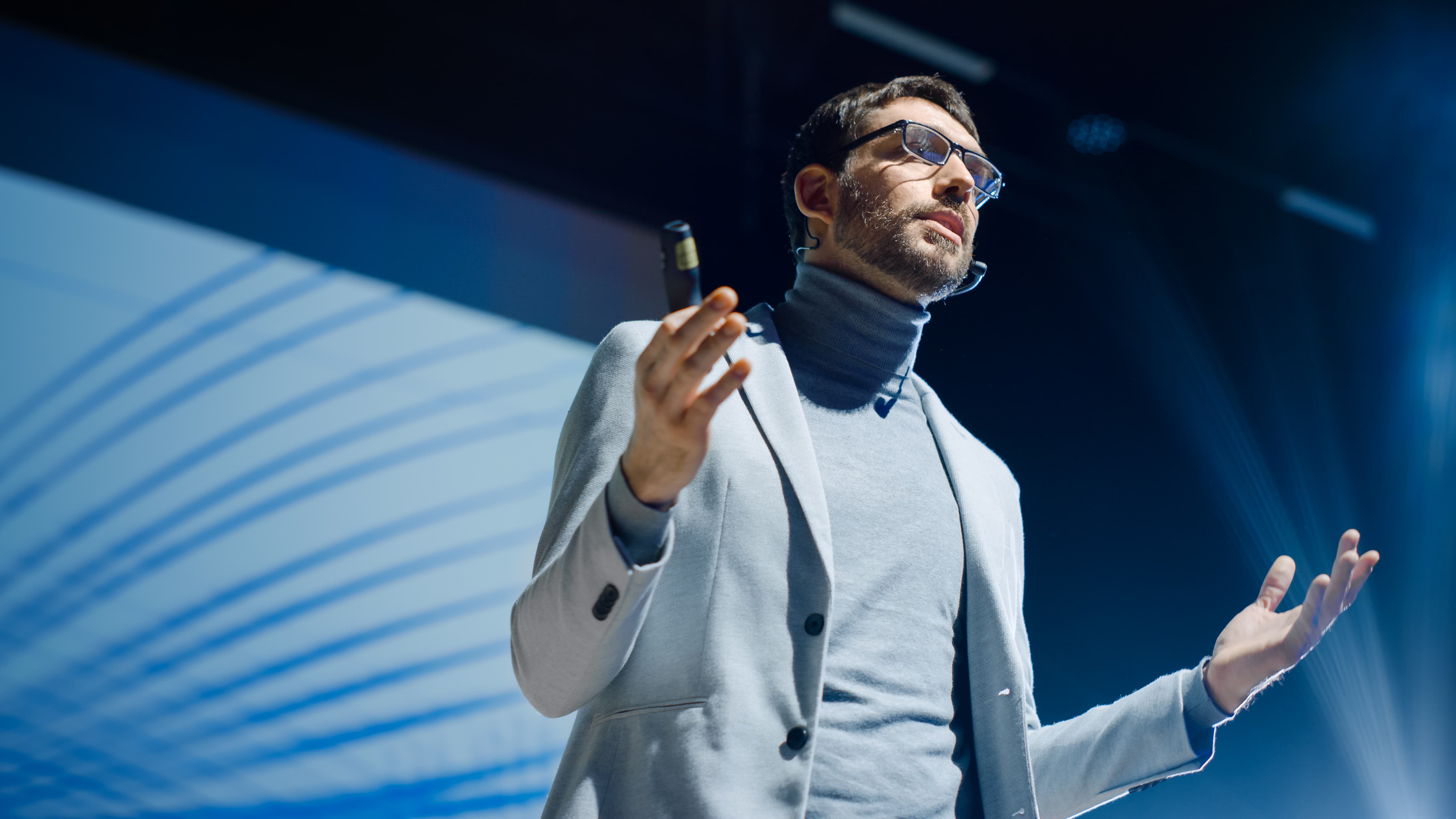 A man presenting in front of a big screen