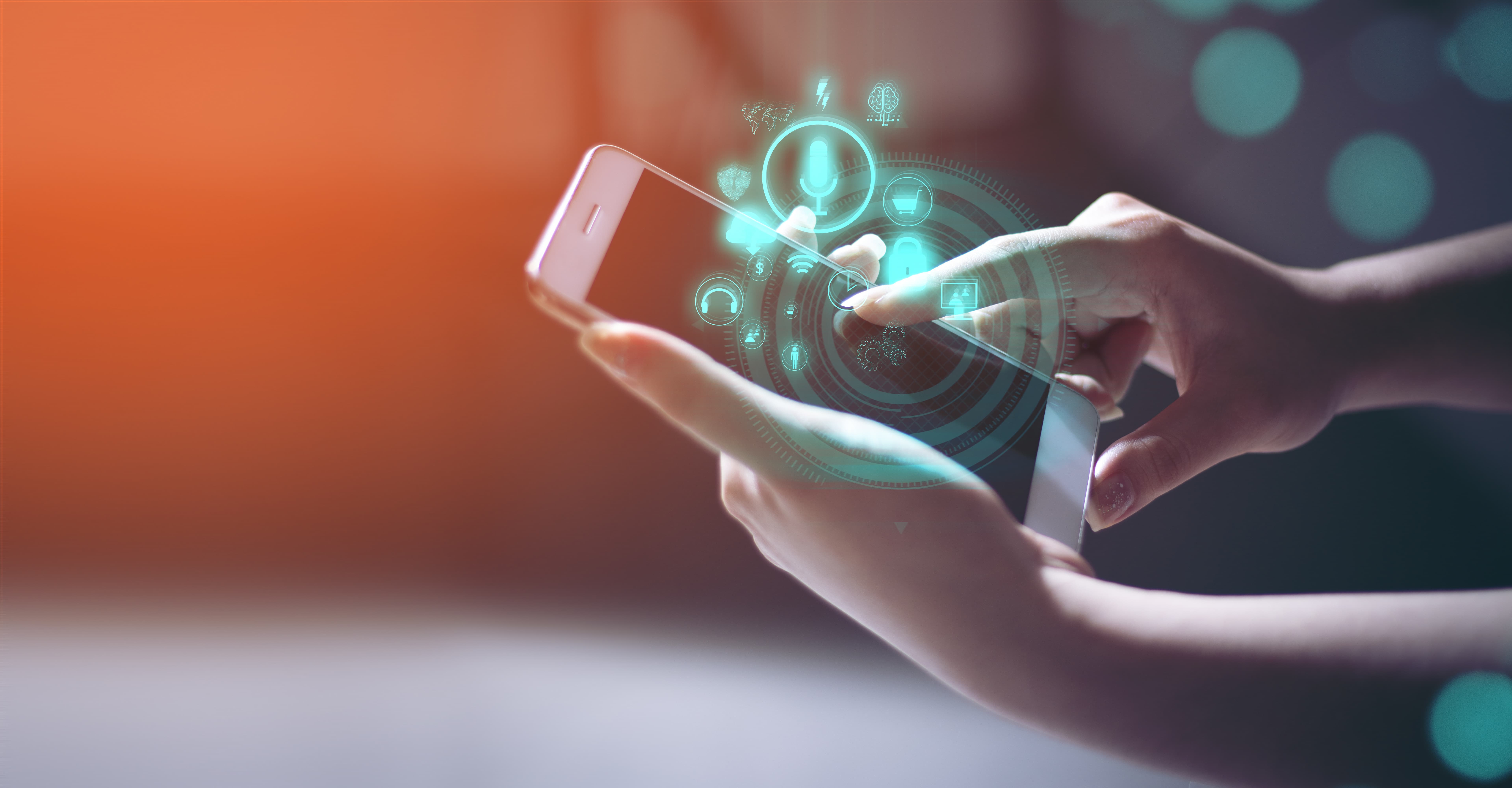 A smartphone in someone hands; the person is touching the blank screen and lots of glowing icons are coming out of it