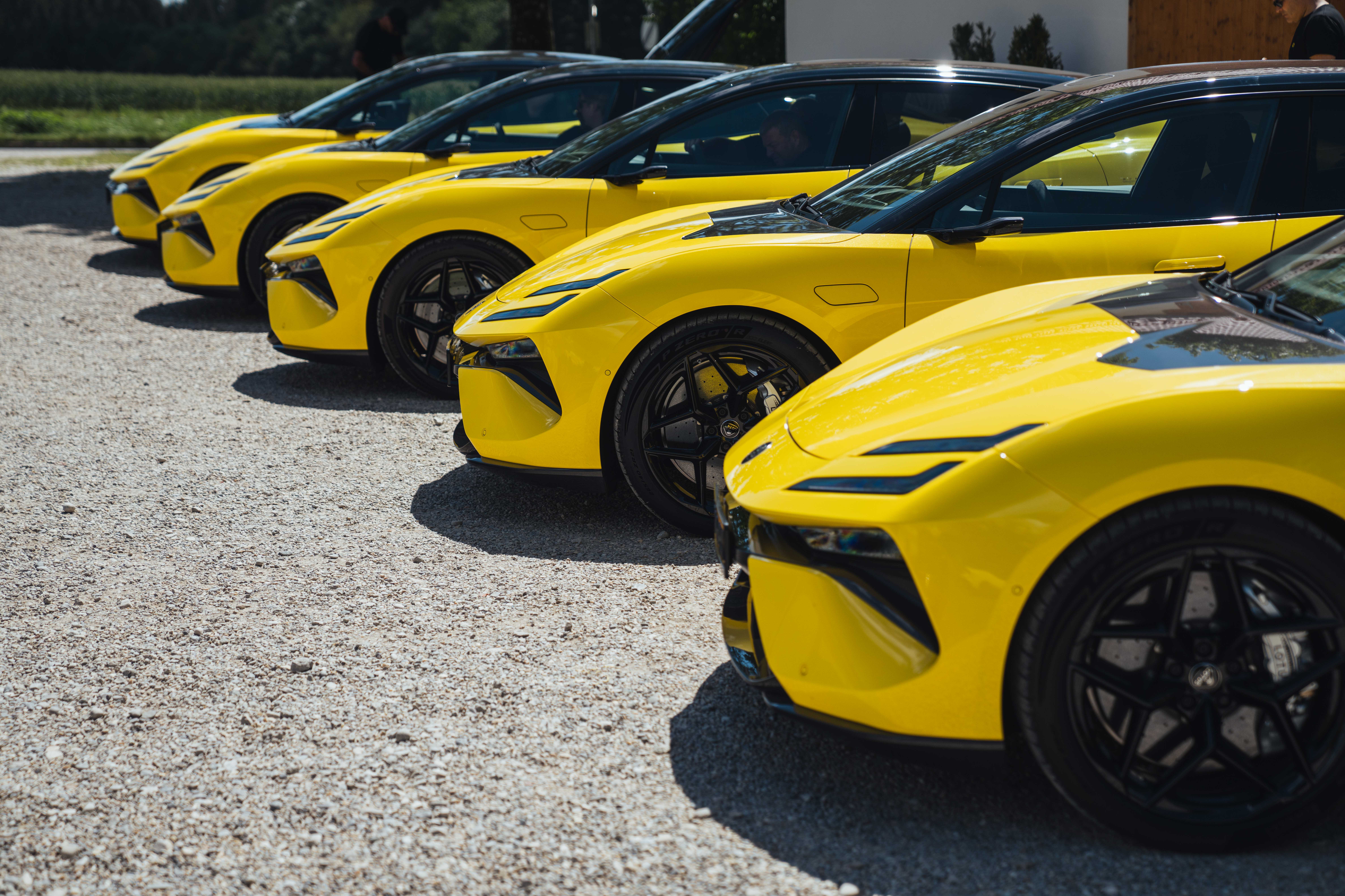 A line up of yellow Lotus cars, with just the bonnets visible